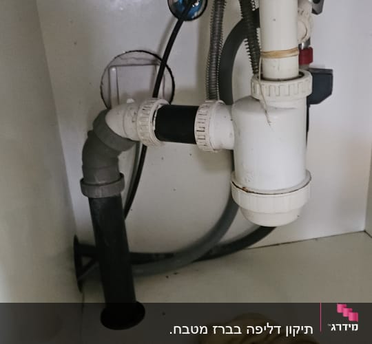 צנרת מתחת לכיור עם חיבורים ומגבת
